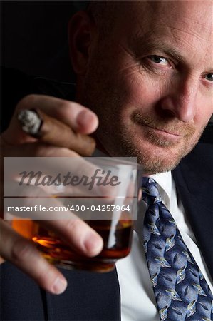Businessman drinking and smoking cigar