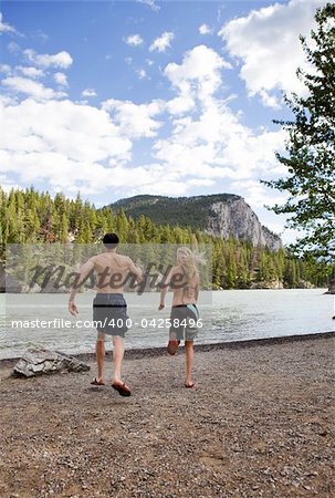 A man and woman running towards the water on a hot summer day