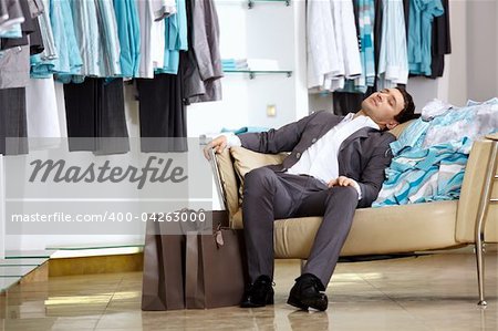 The client of shop of clothes sleeps on the sofa