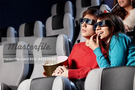 The couple with pop-corn looks cinema in 3d