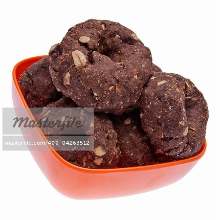 Chocolate doughnut shaped cookies or pet treats in a vibrant orange bowl.