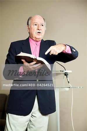 Minister preaching and pointing to the Bible.