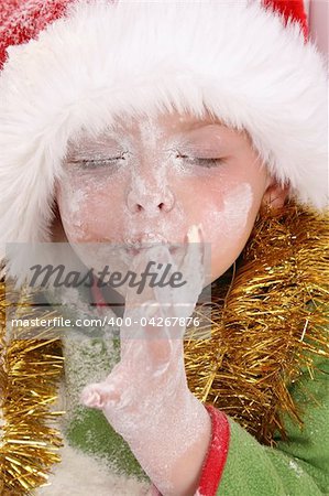 Toddler wearing a christmas hat, baking christmas cookies