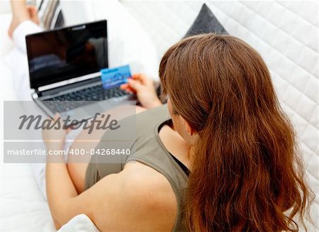 Pregnant woman using credit card to shop from  net