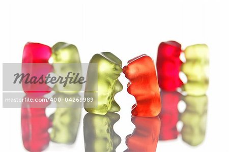 sweet gummy bears dancing on a party on white background