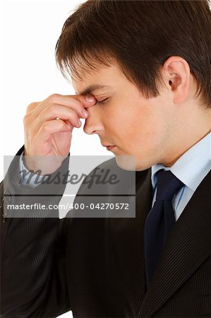 Stressed young  businessman holding fingers at noseband isolated on white