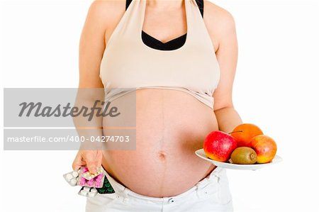 Pregnant woman holding pills and fruits isolated on white. Close-up.