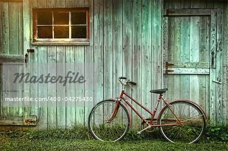 Old bicycle leaning against grungy barn