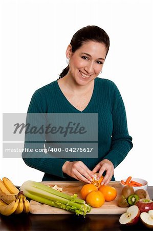 Beautiful happy woman in kitchen peeling orange preparing fruits for juice or salad, isolated.
