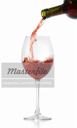 Pouring red wine into a glass isolated on white