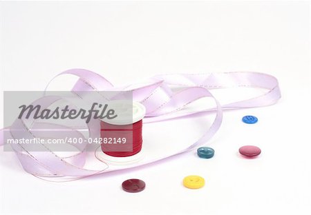 Threads with colored buttons and a pink tape