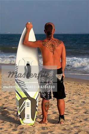 Kitesurfer with surferboard pending a wind