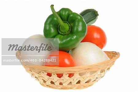 Basket with green pepper, tomatoes, onions and zucchini isolated on white background