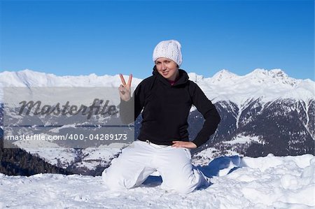 Relaxed girl in high mountains showing peace sign