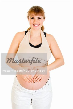 Smiling pregnant woman making heart with her hands on tummy isolated on white