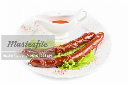 grilled sausage closeup with lettuce and sauce isolated on white
