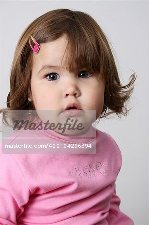 Toddler girl with chubby cheeks wearing a pink top
