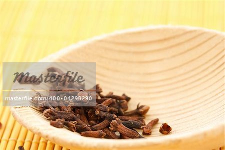 Dried cloves on a wooden spoon