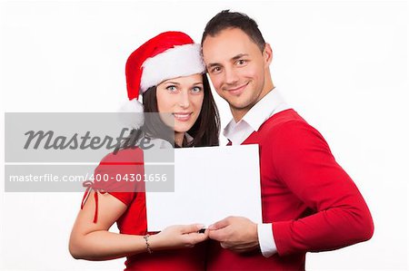 young couple in red christmas clothes holding a white cardboard in hands