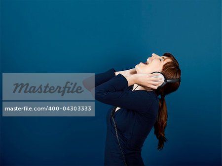 Happy young woman singing and listen music with headphones