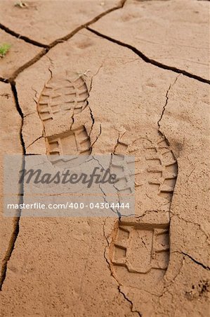 Boot footprints in dry cracked earth