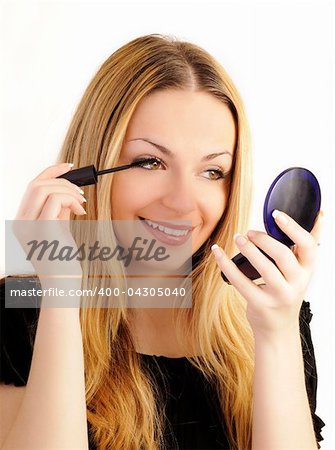 Portrait of a beautiful woman applying make-up, over white background