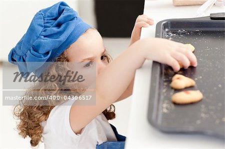 Little girl stealing cookies at home