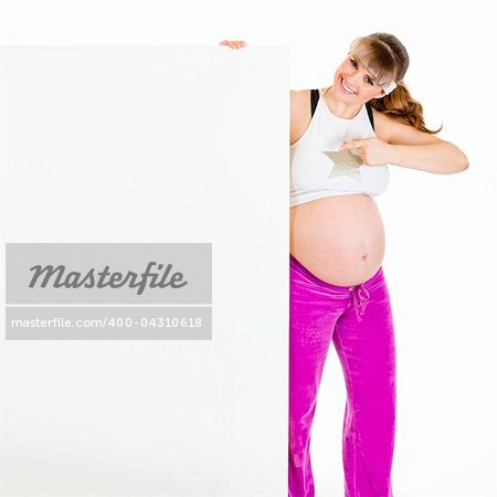 Smiling beautiful pregnant woman  pointing finger at blank billboard  isolated on white