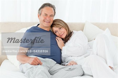 Senior couple lying down on their bed at home