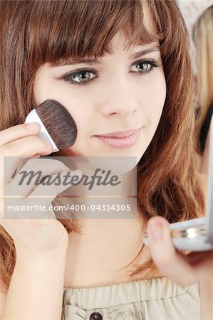 Beautiful young woman with a make-up brush