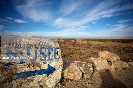 Blue arrow and museum painted on a stone in a small desert village in the south of Morocco