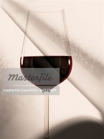 Glass of red wine in front of an open book