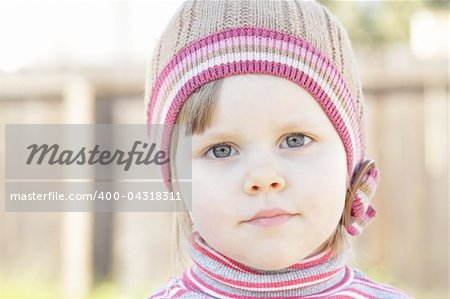 Closeup photo of a cute toddler girl with a knit hat