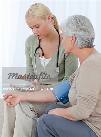 Lovely doctor taking the blood pressure of her patient