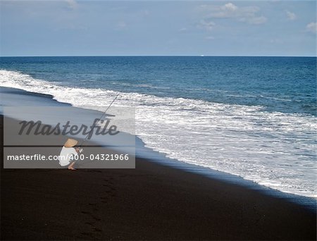 Surreal beach with black sand on Bali island.