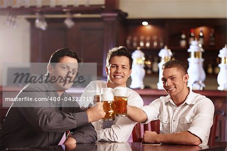 Young business men in a bar with beer