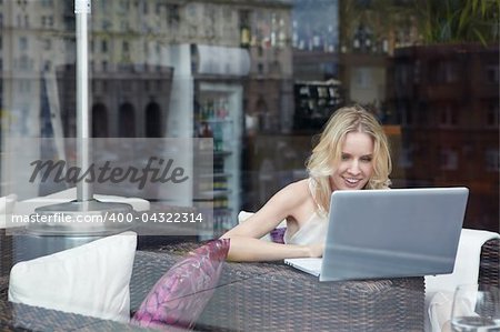 A young girl looks into the laptop in a cafe