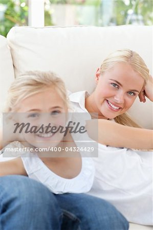 Beautiful woman lying down with her daughter at home
