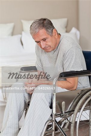 Thoughtful senior man in his wheelchair  at home