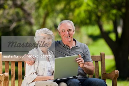 Elderly couple looking at their laptop