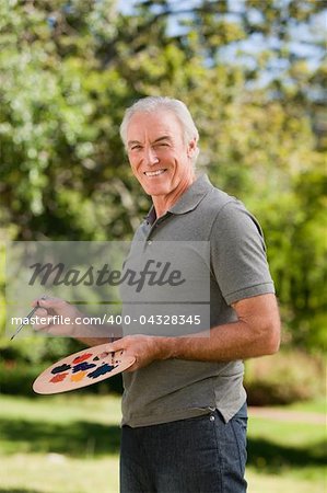 Mature man painting in the garden
