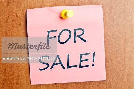 For sale word  post it on wooden wall