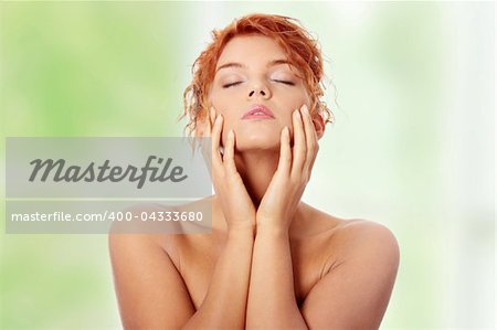 Close-up portrait of sexy caucasian young redhead woman touching her face