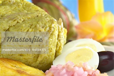 Traditional Peruvian food called Juane from the jungle area, in which rice, eggs and different kinds of meat are wrapped into bijao leaves, and are served with fried plantains, eggs and black olives (Selective Focus, Focus on the front of the rice)