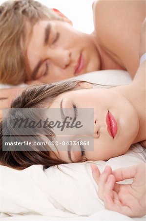 Beautiful young couple sleeping in bed.