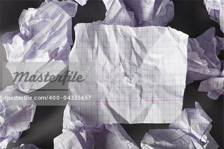 sheet of paper and crumpled wads on table.