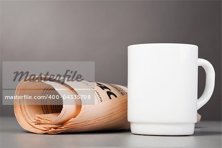 close-up view of white cup and folded newspaper