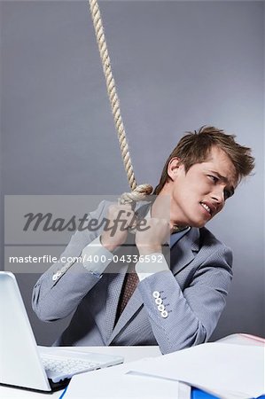 A young businessman tightens the noose on his neck