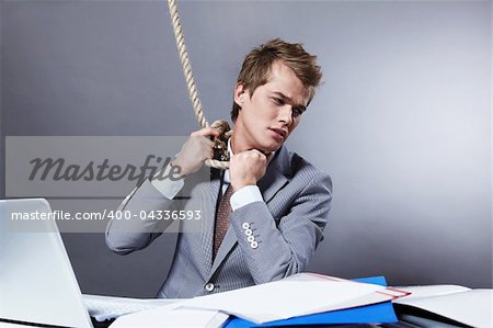 A young businessman tightens the noose on
