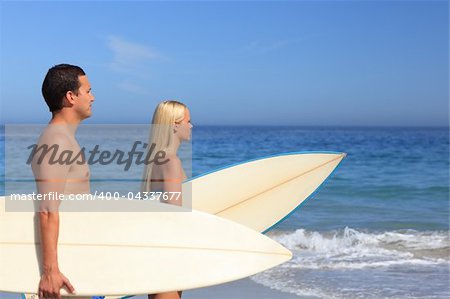 Lovers with their surfboards